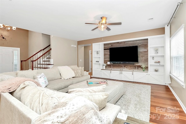 1618 Bay Meadows Ave NW, Concord, NC 28027 - living area featuring light wood finished floors, ceiling fan, stairway, built in features, and baseboards