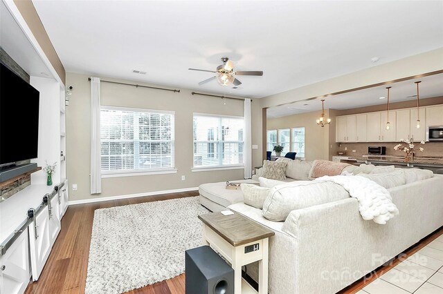 1618 Bay Meadows Ave NW, Concord, NC 28027 - living room with ceiling fan, light wood-type flooring, a chandelier, and baseboards