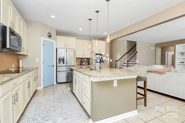 1618 Bay Meadows Ave NW, Concord, NC 28027 - kitchen with stainless steel appliances, a sink, light tile patterned floors, a breakfast bar, and decorative backsplash