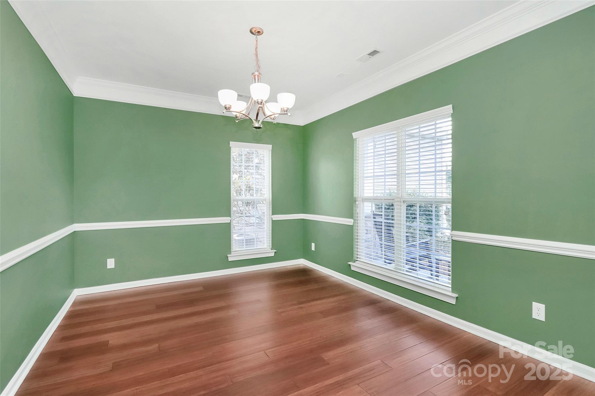 1618 Bay Meadows Ave NW, Concord, NC 28027 - empty room featuring a chandelier, wood finished floors, baseboards, and ornamental molding