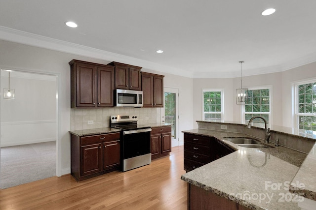 6718 Heritage Orchard Way, Huntersville, NC 28078 - kitchen with appliances with stainless steel finishes, a sink, light wood finished floors, pendant lighting, and tasteful backsplash