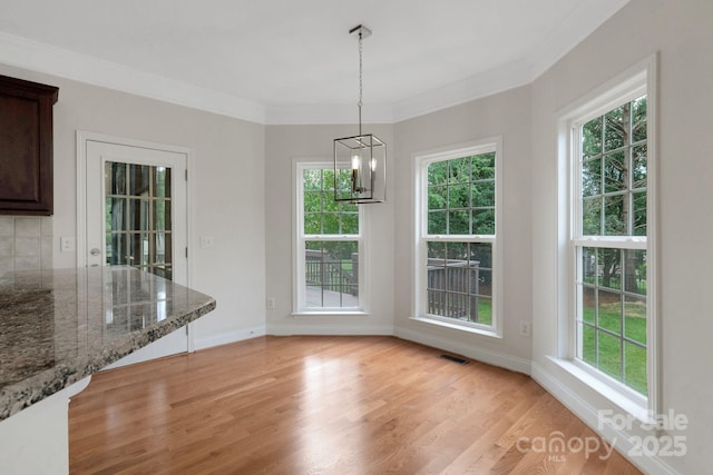 6718 Heritage Orchard Way, Huntersville, NC 28078 - unfurnished dining area with plenty of natural light, light wood-style floors, baseboards, and crown molding