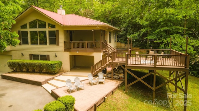571 Ivy Ridge Cir, Sylva, NC 28779 - rear view of property with stairway, stucco siding, metal roof, a chimney, and a patio