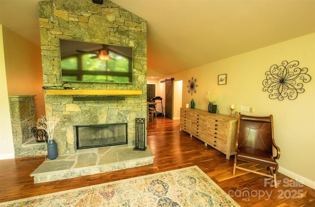 571 Ivy Ridge Cir, Sylva, NC 28779 - living area with vaulted ceiling, wood finished floors, a stone fireplace, and baseboards