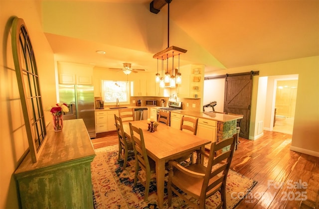 571 Ivy Ridge Cir, Sylva, NC 28779 - dining area featuring a barn door, light wood-style floors, lofted ceiling, a ceiling fan, and baseboards
