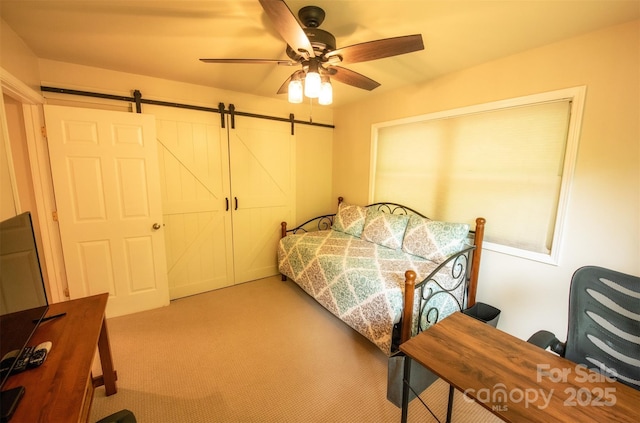 571 Ivy Ridge Cir, Sylva, NC 28779 - bedroom with light carpet, a barn door, and a ceiling fan
