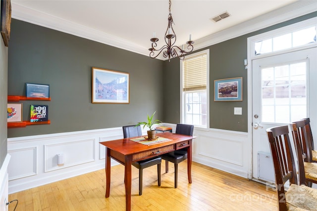 123 Singleton Rd, Mooresville, NC 28117 - dining space featuring a chandelier, crown molding, wainscoting, light wood-type flooring, and a decorative wall