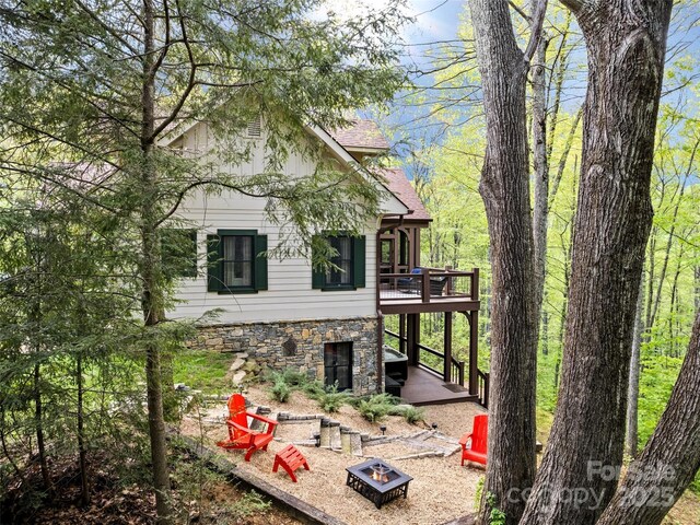 62 Blair Athel Pt, Waynesville, NC 28786 - view of home's exterior featuring a fire pit, a wooden deck, stone siding, stairs, and roof with shingles