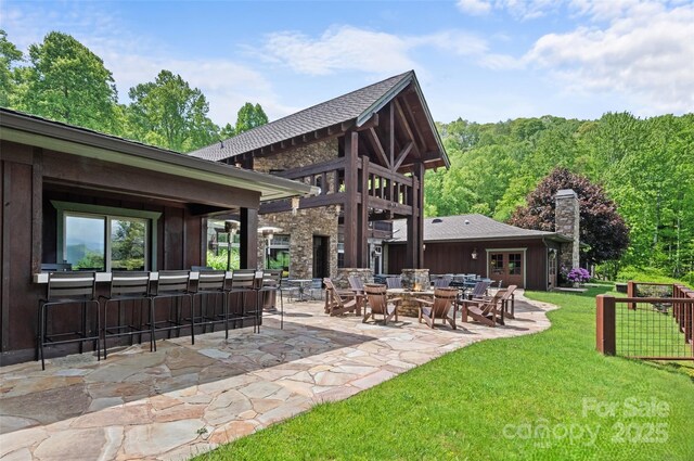 62 Blair Athel Pt, Waynesville, NC 28786 - rear view of property featuring a patio, a lawn, a chimney, and a fire pit