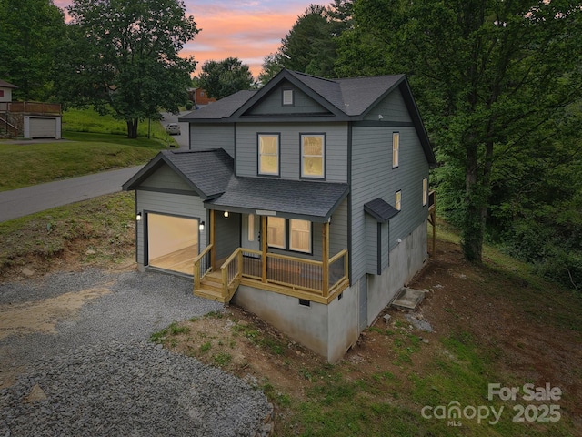 12 Whipoorwill Way, Waynesville, NC 28786 - view of front of house featuring a porch, roof with shingles, a garage, and gravel driveway