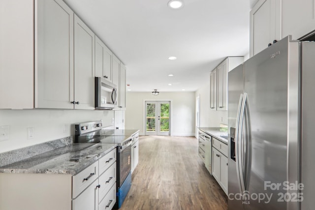 12 Whipoorwill Way, Waynesville, NC 28786 - kitchen featuring appliances with stainless steel finishes, french doors, wood finished floors, recessed lighting, and light stone countertops