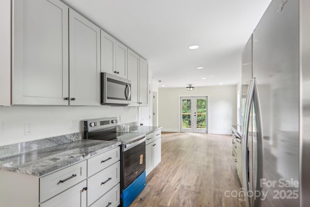 12 Whipoorwill Way, Waynesville, NC 28786 - kitchen featuring appliances with stainless steel finishes, french doors, light wood-style flooring, recessed lighting, and white cabinetry