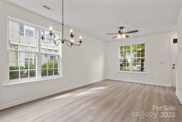 5529 Seths Dr, Charlotte, NC 28269 - empty room featuring a chandelier, light wood-style floors, ceiling fan, and baseboards