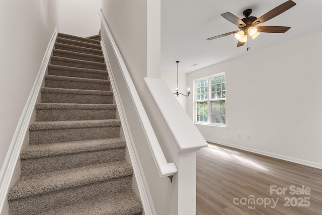 5529 Seths Dr, Charlotte, NC 28269 - stairway featuring wood finished floors, a ceiling fan, baseboards, and a chandelier