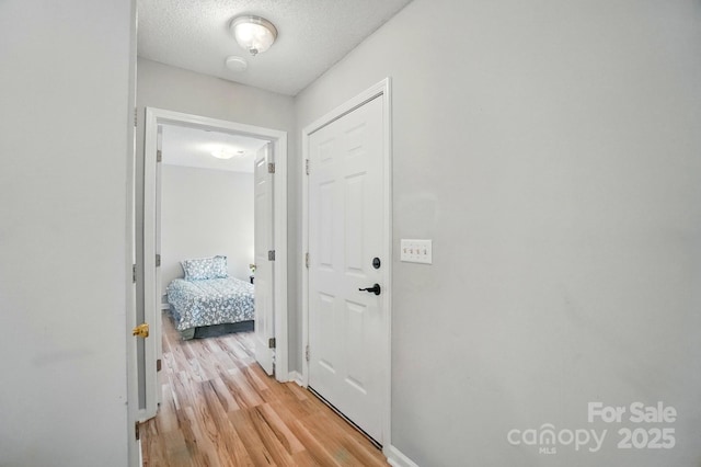 317 Cedarcroft Dr, Mooresville, NC 28115 - hall with light wood-type flooring, a textured ceiling, and baseboards