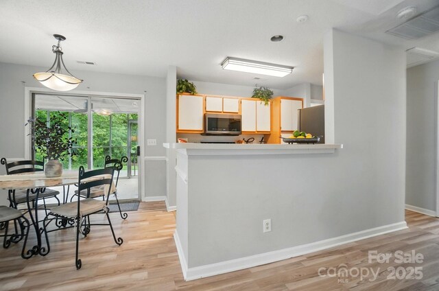 317 Cedarcroft Dr, Mooresville, NC 28115 - kitchen with stainless steel appliances, light wood-style floors, baseboards, decorative light fixtures, and light countertops