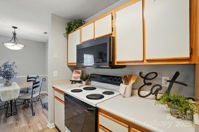 317 Cedarcroft Dr, Mooresville, NC 28115 - kitchen featuring range with electric stovetop, black microwave, light countertops, hanging light fixtures, and a textured ceiling