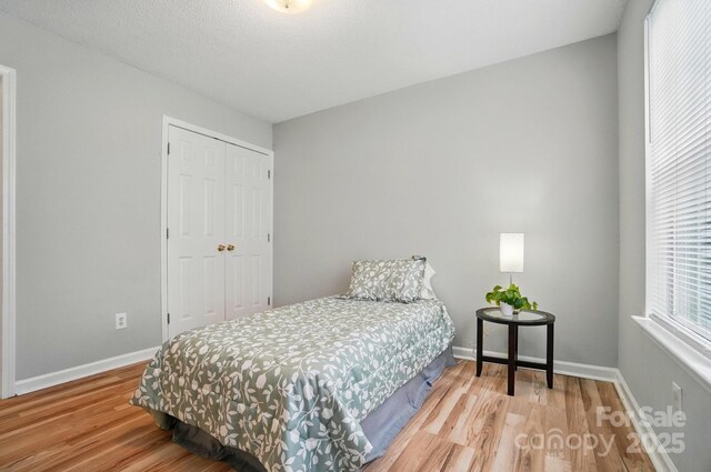 317 Cedarcroft Dr, Mooresville, NC 28115 - bedroom with wood finished floors, a closet, and baseboards