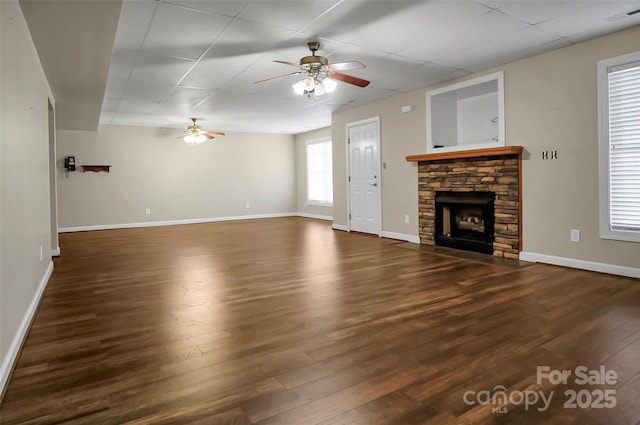 814 Settlers Dr, Cherryville, NC 28021 - unfurnished living room featuring ceiling fan, a stone fireplace, wood finished floors, and baseboards