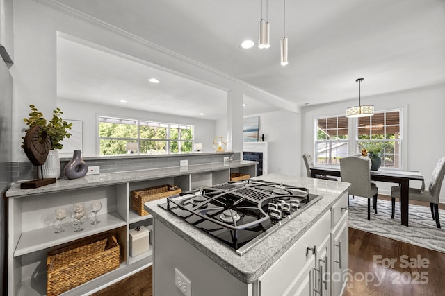 917 Dent Ct, Charlotte, NC 28210 - kitchen with stovetop with downdraft, dark wood-style flooring, white cabinetry, light stone countertops, and a fireplace