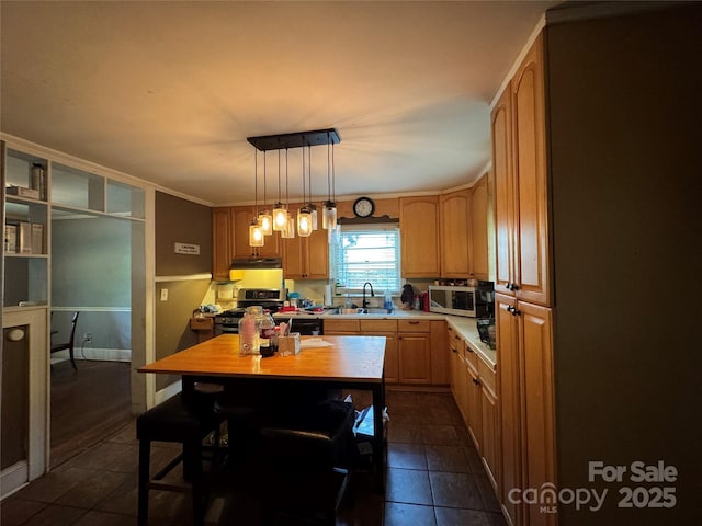kitchen featuring appliances with stainless steel finishes, a sink, light countertops, and dark tile patterned flooring