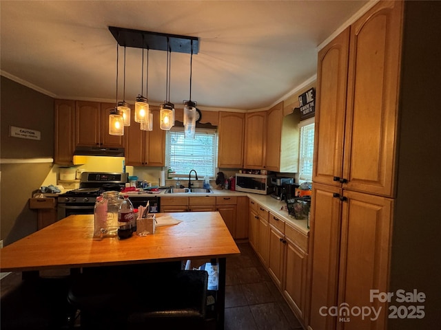 kitchen featuring a sink, under cabinet range hood, stainless steel gas range oven, wooden counters, and pendant lighting
