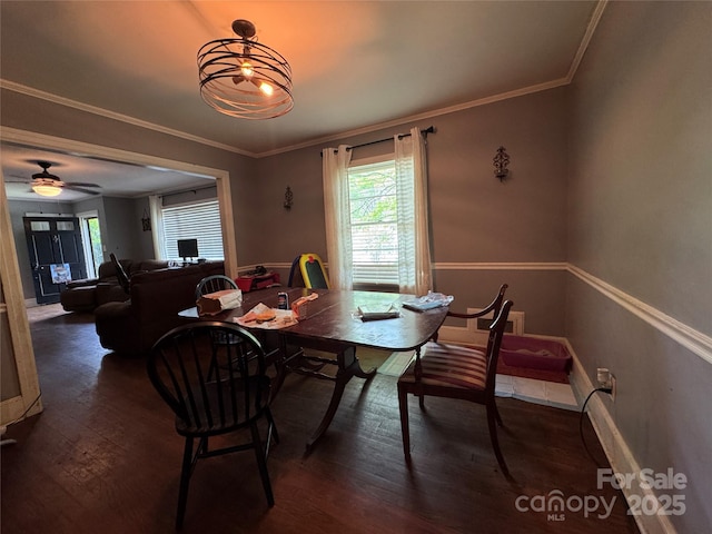 dining space featuring dark wood finished floors, baseboards, and crown molding