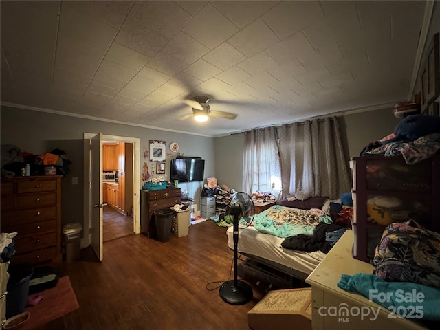 bedroom with crown molding, dark wood-style floors, and a ceiling fan