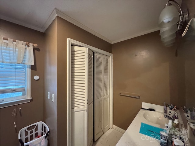 bathroom featuring crown molding, baseboards, and a sink