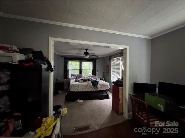 carpeted bedroom with crown molding and ceiling fan