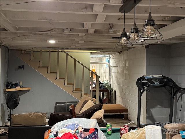 basement featuring stairs and concrete block wall