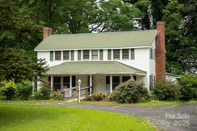 1612 Forum Ln, Iron Station, NC 28080 - view of front of home featuring a porch, a chimney, metal roof, and view of wooded area