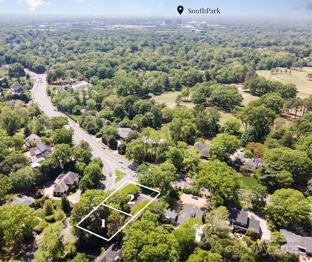 aerial view of property's location with property boundaries highlighted and a heavily wooded area