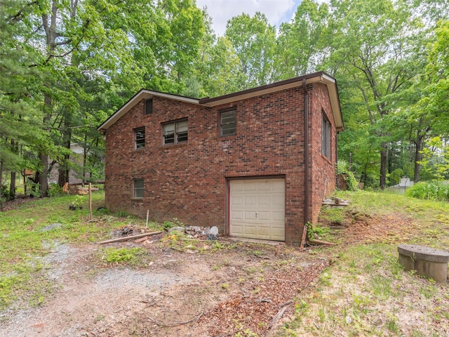 3 N Marley Dr, Flat Rock, NC 28731 - view of side of property with an attached garage, brick siding, and dirt driveway