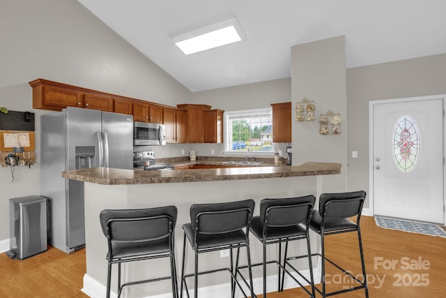 170 Wagon Wheel Way Unit 4, Salisbury, NC 28147 - kitchen with stainless steel appliances, light wood finished floors, lofted ceiling, a kitchen bar, and dark countertops