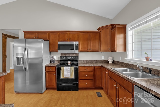 170 Wagon Wheel Way Unit 4, Salisbury, NC 28147 - kitchen featuring appliances with stainless steel finishes, a sink, light wood-type flooring, high vaulted ceiling, and brown cabinetry