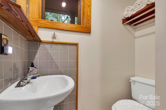 214 Laurel Mountain Trl, Saluda, NC 28773 - bathroom featuring a sink, toilet, tile walls, and tasteful backsplash