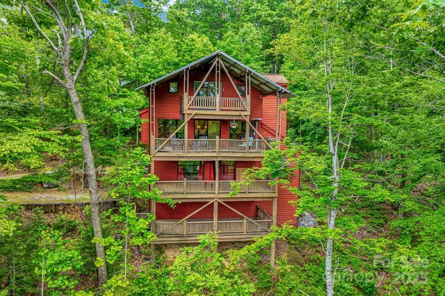 214 Laurel Mountain Trl, Saluda, NC 28773 - view of front of home with a balcony and a view of trees
