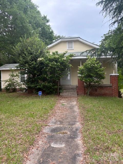 view of front of home with asphalt driveway and a front yard