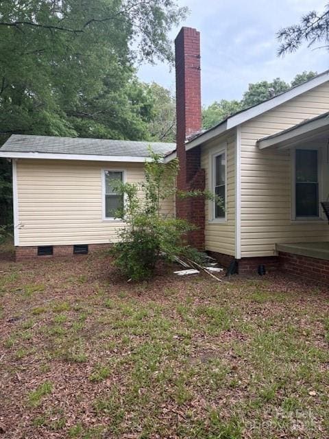 rear view of house featuring a chimney and crawl space