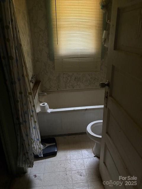 bathroom featuring tile patterned floors, toilet, a tub to relax in, and a shower with curtain