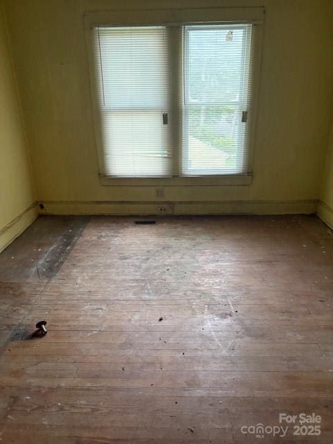spare room with hardwood / wood-style flooring and baseboards