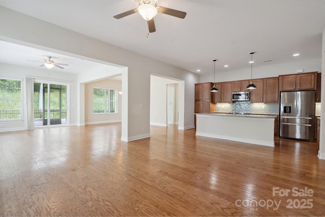 467 Granite Lake Ct, Denver, NC 28037 - unfurnished living room featuring a ceiling fan, recessed lighting, light wood-style flooring, baseboards, and a sink