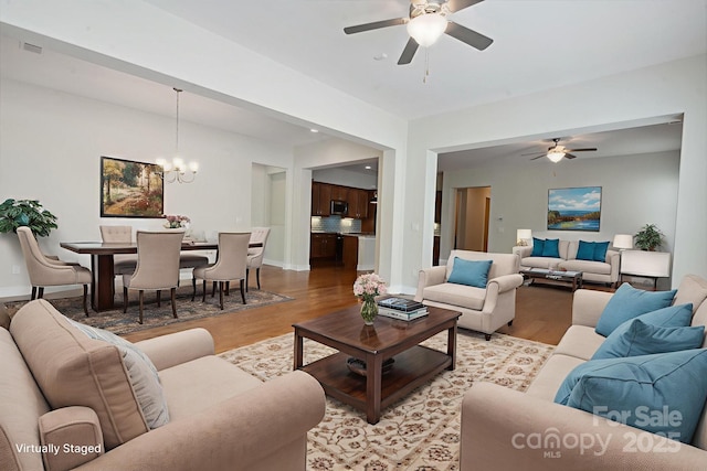 467 Granite Lake Ct, Denver, NC 28037 - living room featuring a ceiling fan, light wood-style flooring, a chandelier, and baseboards