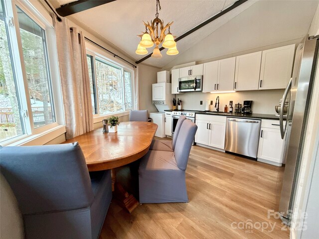 109 Beechwood Ln, Beech Mountain, NC 28604 - dining space featuring a chandelier, lofted ceiling, plenty of natural light, and light wood-style flooring