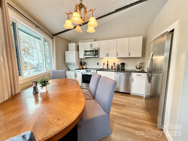 109 Beechwood Ln, Beech Mountain, NC 28604 - kitchen with stainless steel appliances, lofted ceiling, a chandelier, white cabinets, and dark countertops