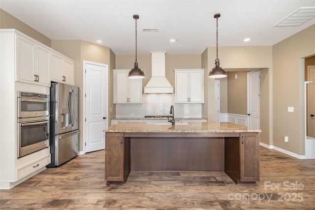 3105 Bonterra Blvd, Indian Trail, NC 28079 - kitchen featuring stainless steel appliances, custom exhaust hood, wood finished floors, white cabinets, and recessed lighting