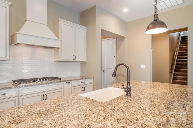 3105 Bonterra Blvd, Indian Trail, NC 28079 - kitchen with custom exhaust hood, stainless steel gas stovetop, a sink, backsplash, and white cabinets