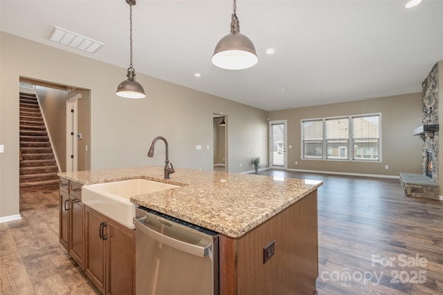 3105 Bonterra Blvd, Indian Trail, NC 28079 - kitchen featuring stainless steel dishwasher, a sink, pendant lighting, a kitchen island with sink, and brown cabinets