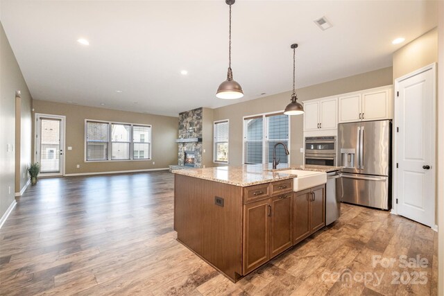 3105 Bonterra Blvd, Indian Trail, NC 28079 - kitchen with stainless steel appliances, a sink, light wood finished floors, a center island with sink, and recessed lighting